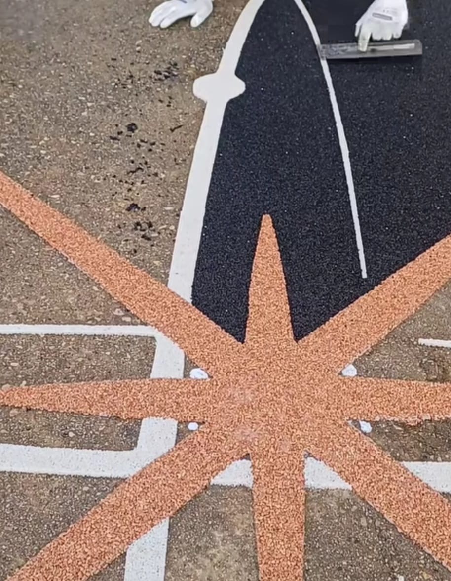 Resin bound flag and star design being installed in copper, black and white stone