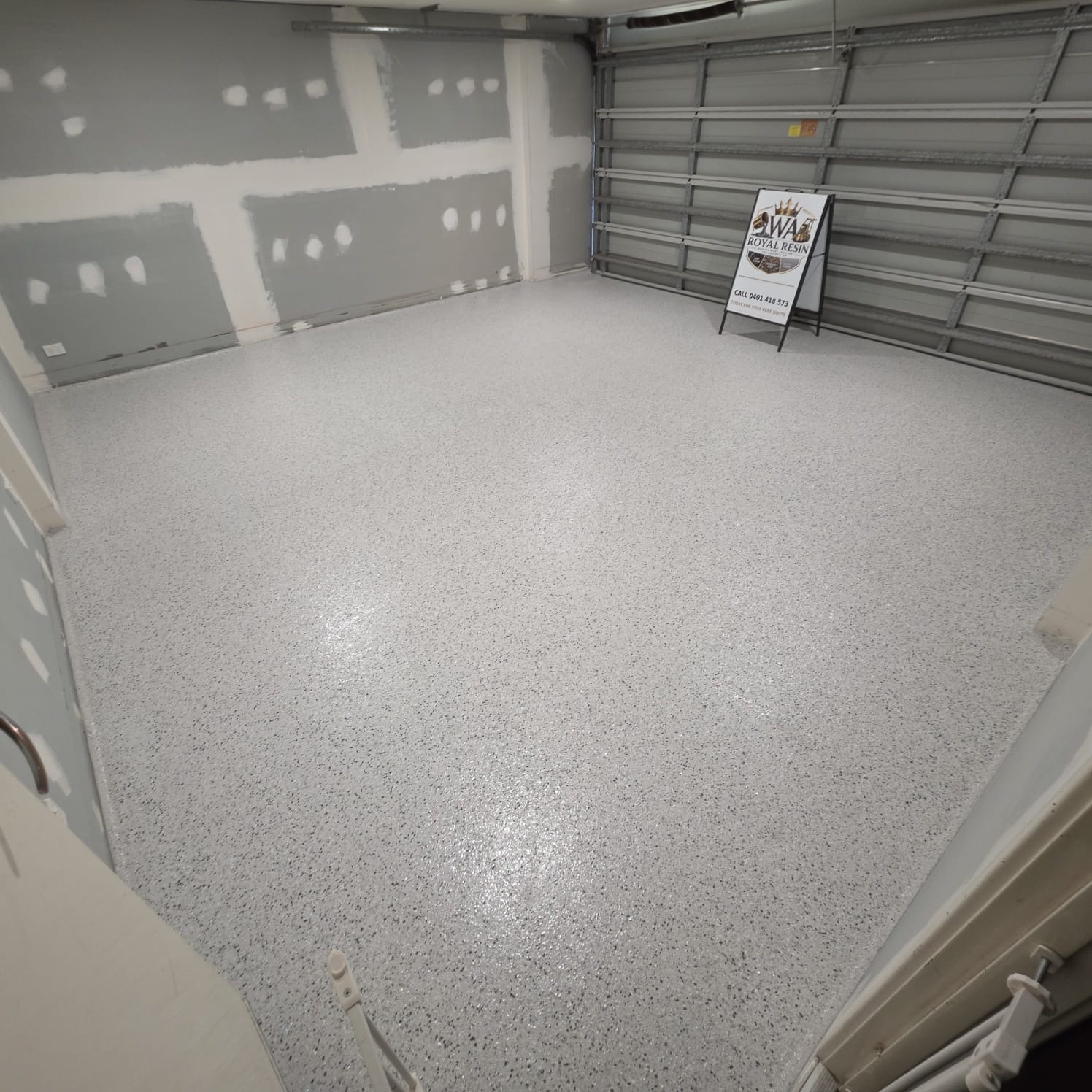 Double garage with a light grey flake floor and WA Royal Resin sign in the doorway