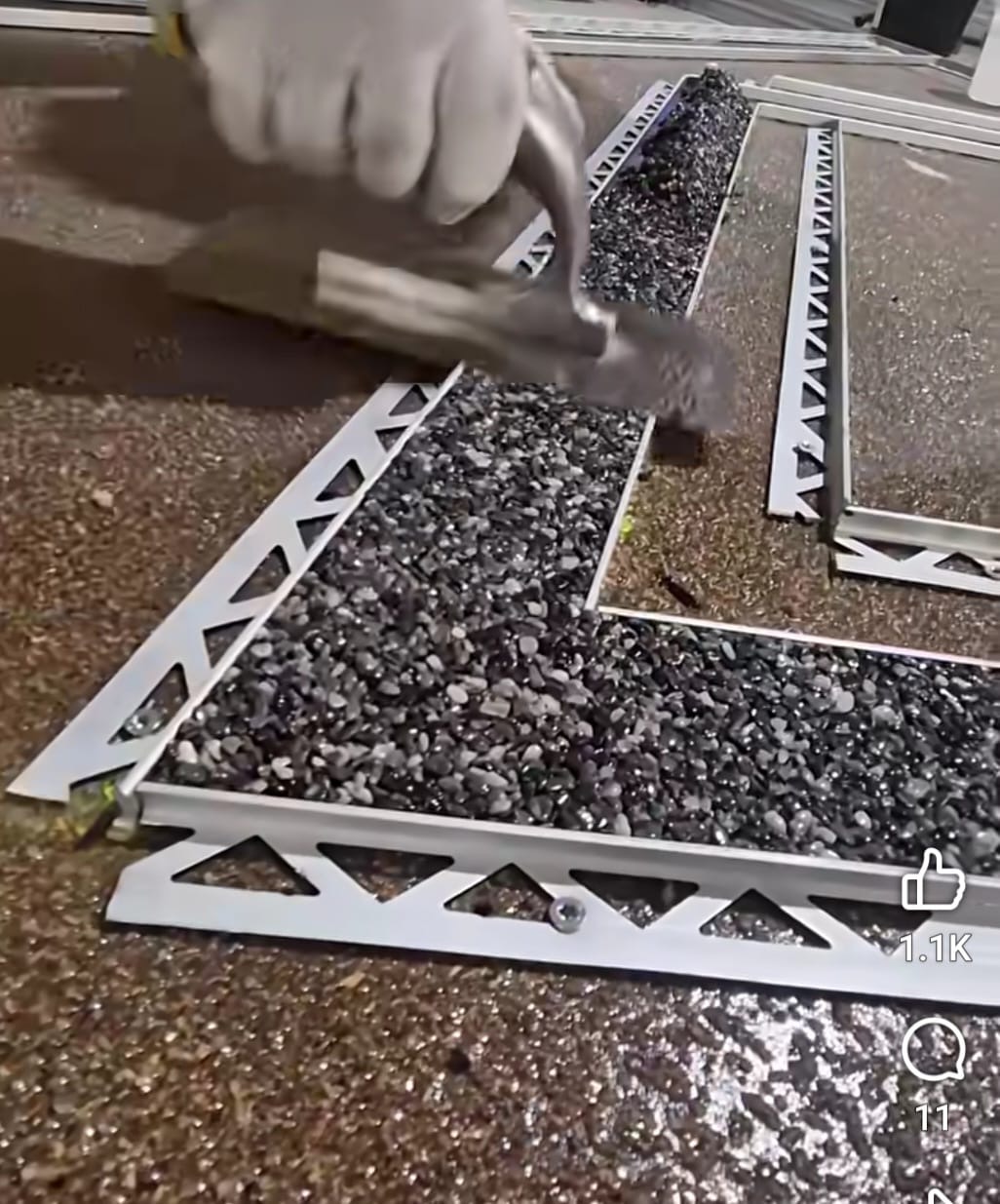 Installer trowelling dark resin bound stone into aluminium edging templates
