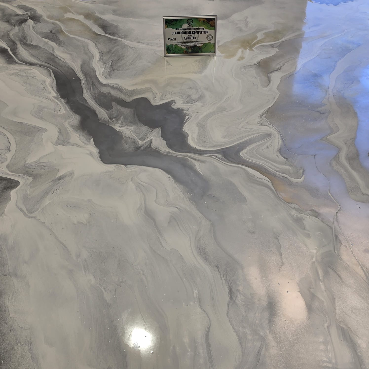 Silver and charcoal marbled metallic epoxy floor with a mirror finish