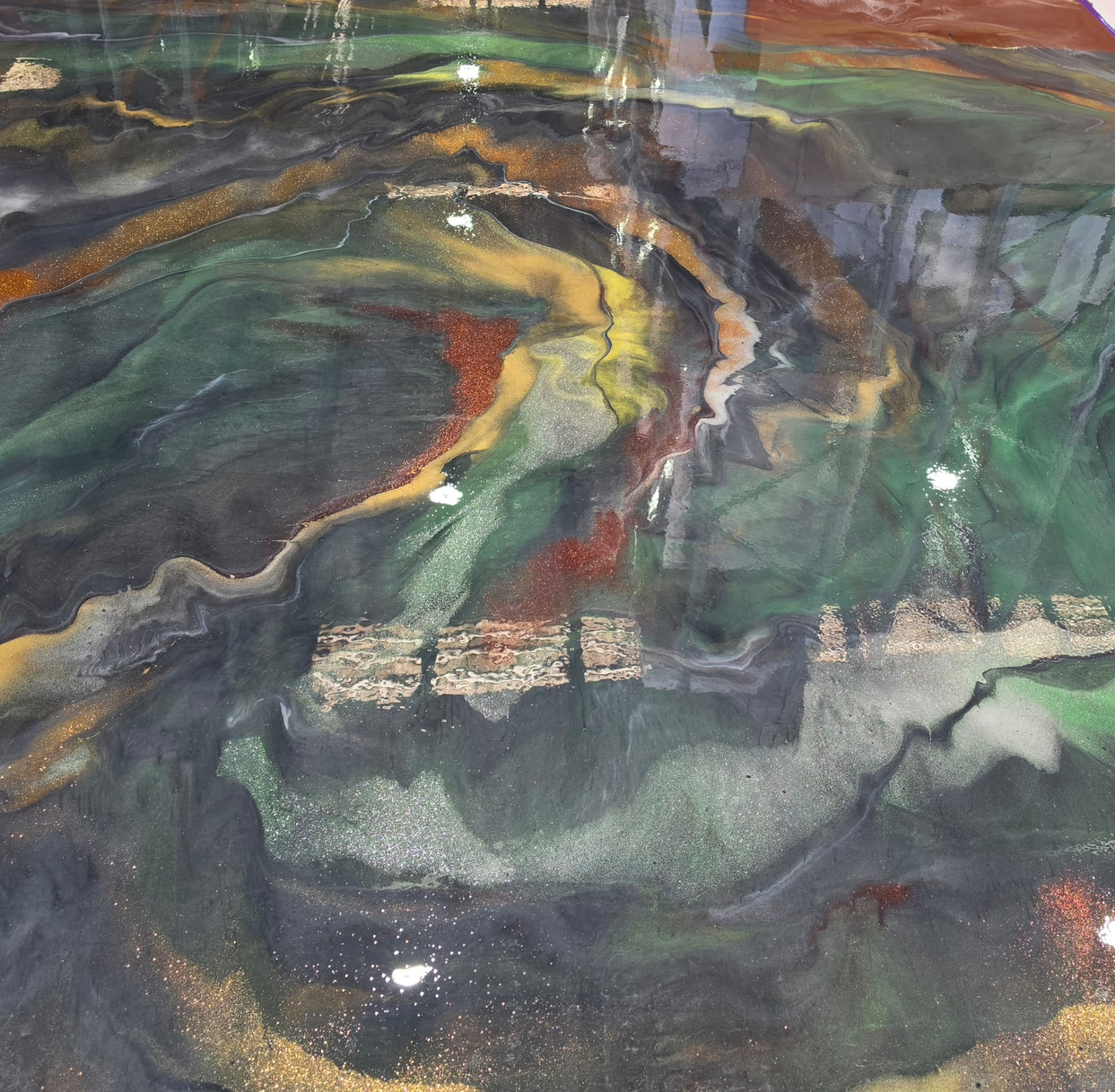 Metallic resin floor combining moss green, ember red and silver pigment