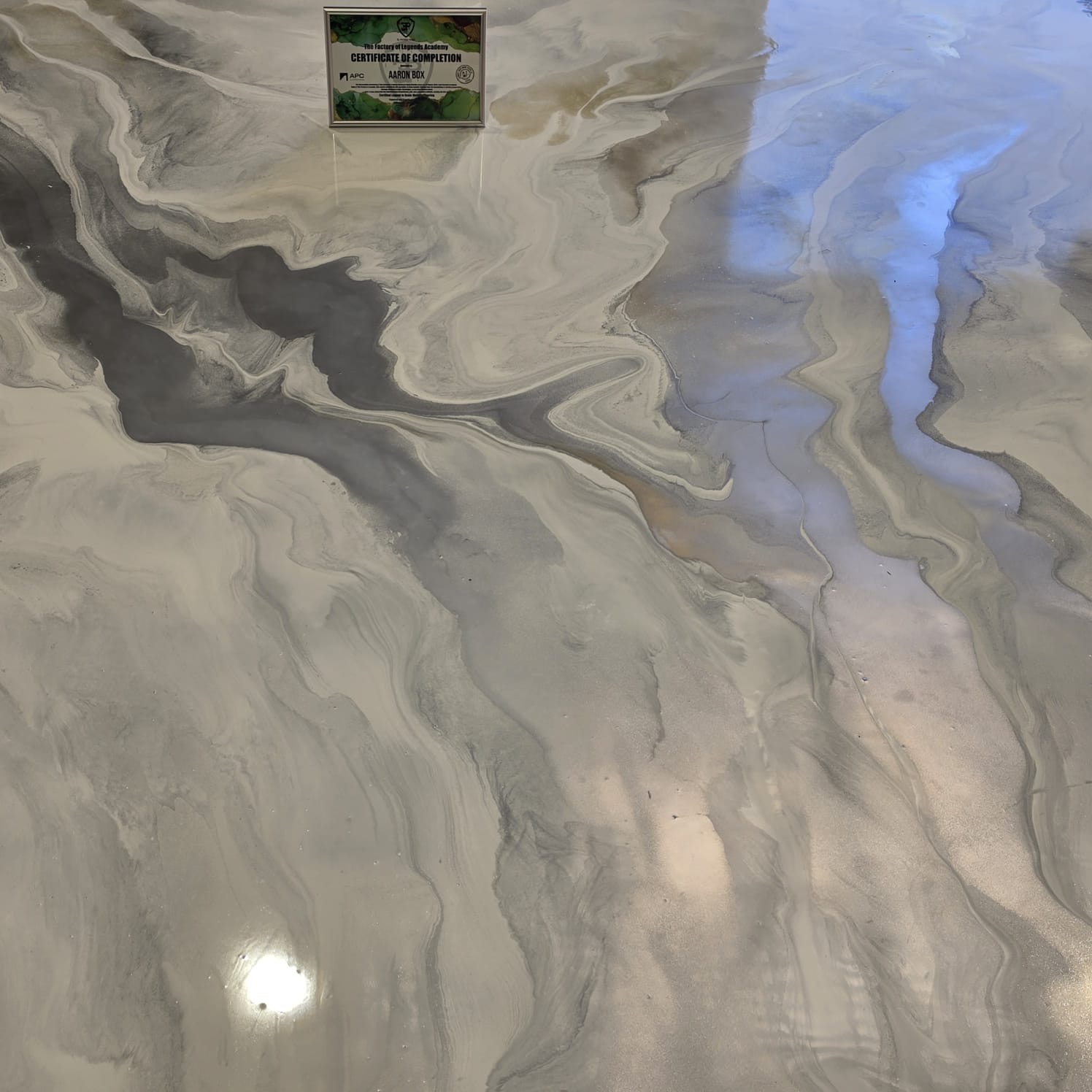 Pearl white and grey marbled metallic epoxy floor with soft blue light reflection