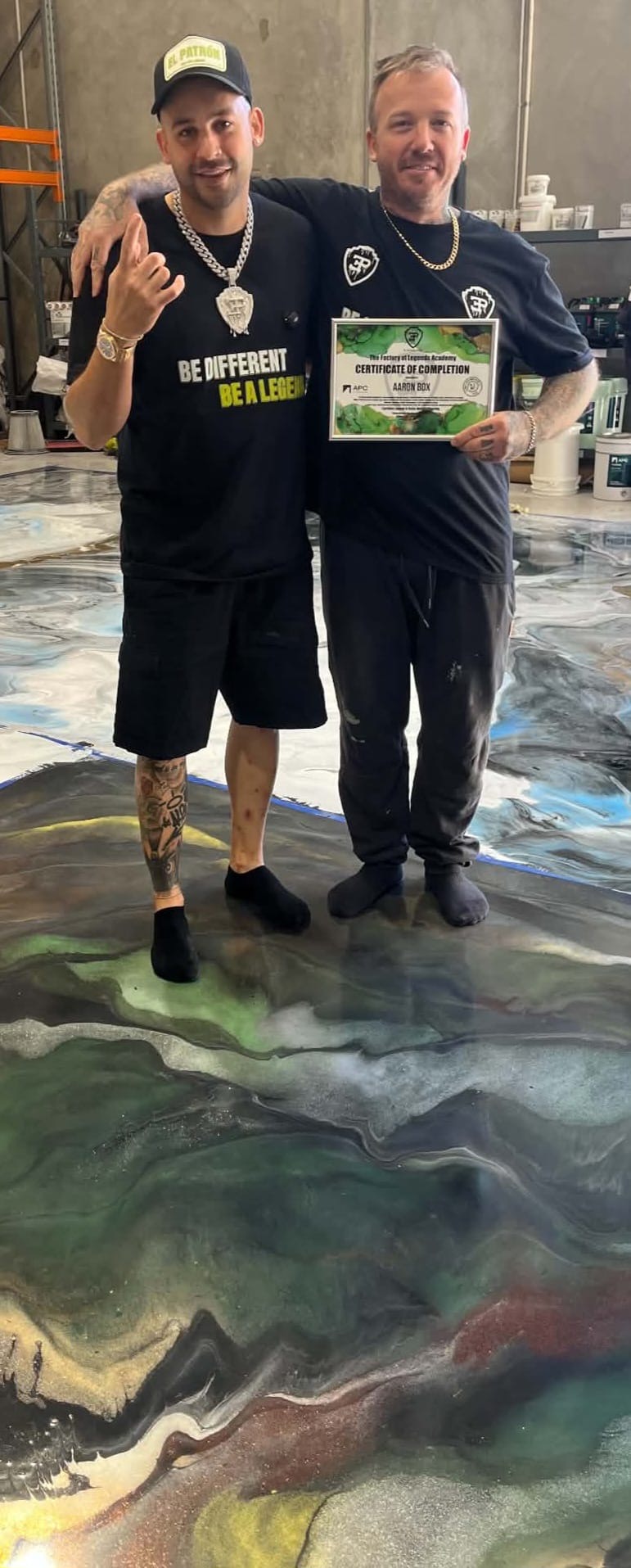 Aaron Box and Sam Serio standing on a finished metallic resin floor holding a training certificate